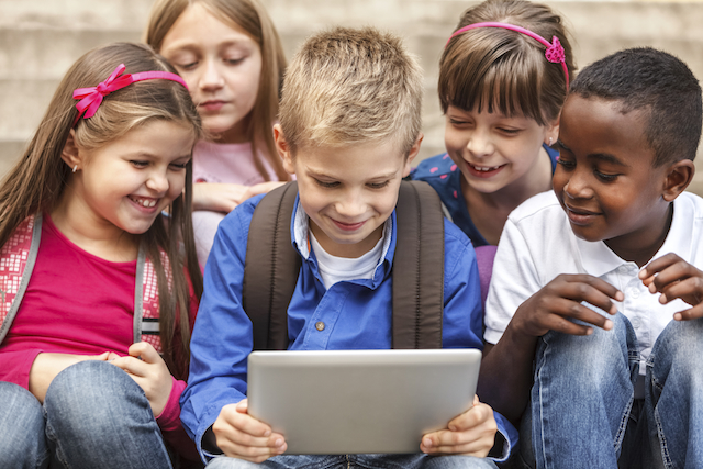 School children using digital tablet outside